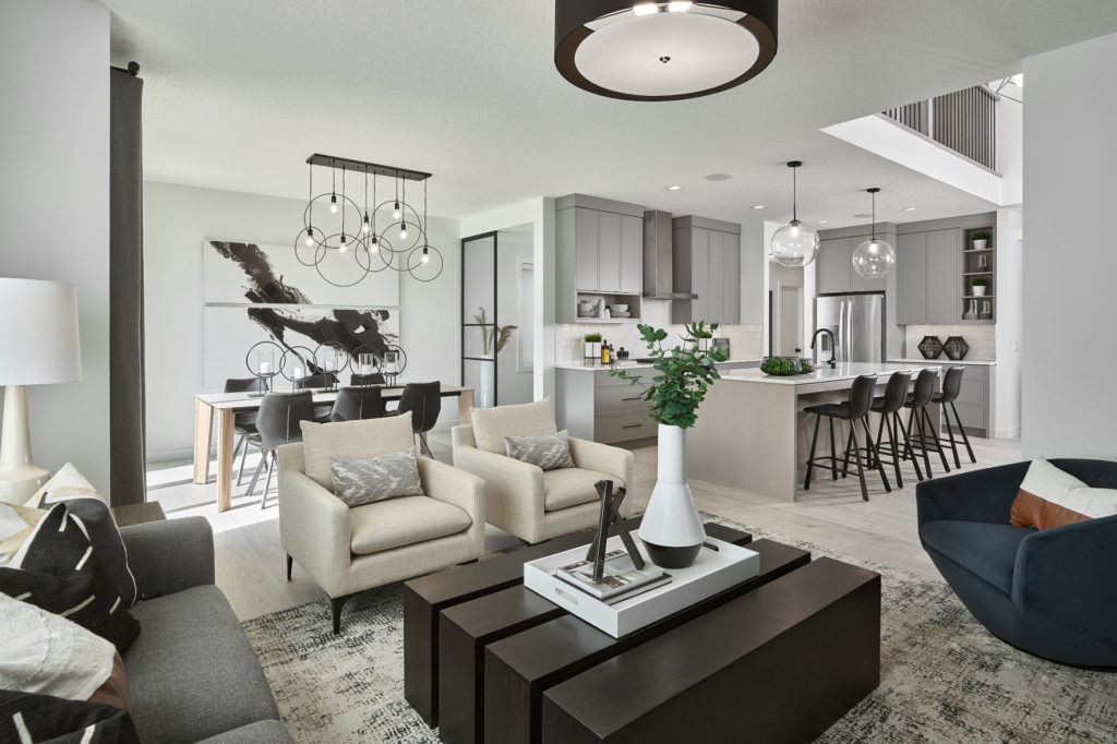 a spacious open concept living room with modern furniture connected to the kitchen and dining area