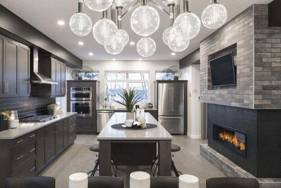 a modern kitchen in dark tones with a fireplace and tv an a large kitchen island