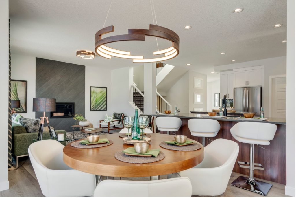 a modern dining area with a large round table connected to the kitchen and living room